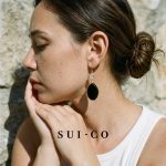 Model wearing Sui Artisan Noir black onyx drop statement earrings