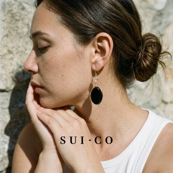 Model wearing Sui Artisan Noir black onyx drop statement earrings