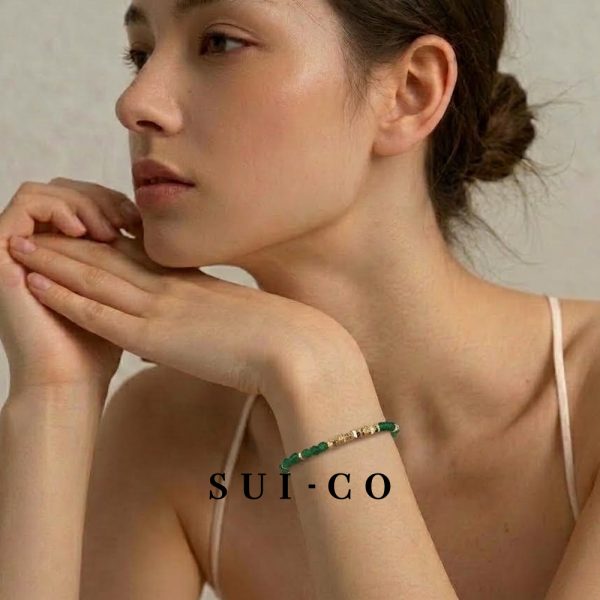 Model wearing Sui Artisan Esme emerald czech crystal bracelet with gold chain extender
